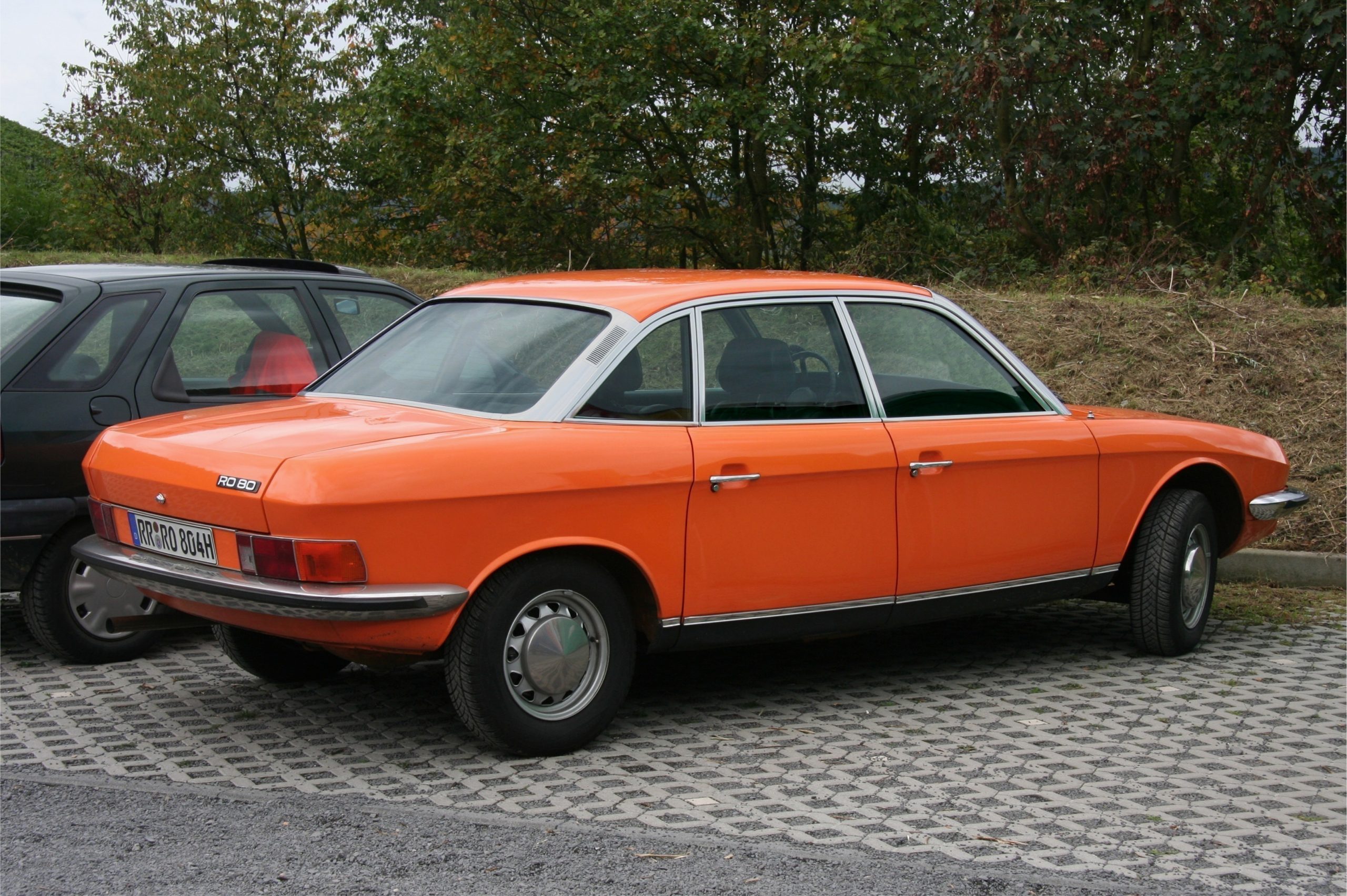 Oranger NSU Ro 80 in reiner Seitenansicht mit keilfoermiger Silhouette